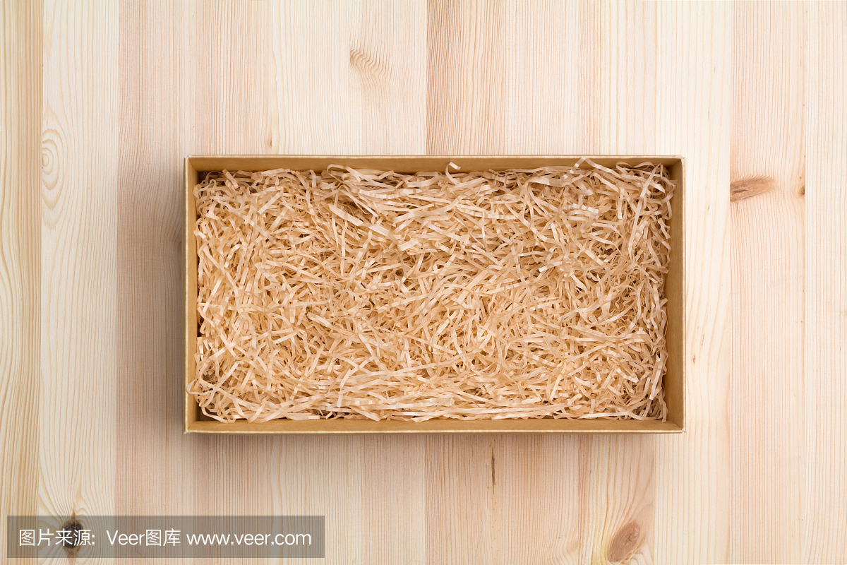 礼盒用装饰稻草放在木桌上,俯视图